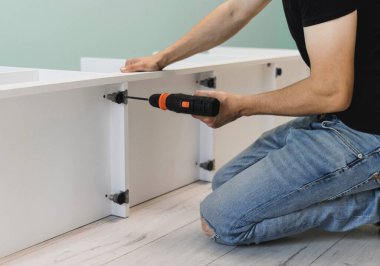 Genç bir zanaatkar mobilya montajı yapıyor. Teyidi yakın plan çekiyoruz. Profesyonel mobilya montajı. Yeni mobilya montajı. Mobilya kurulumu.