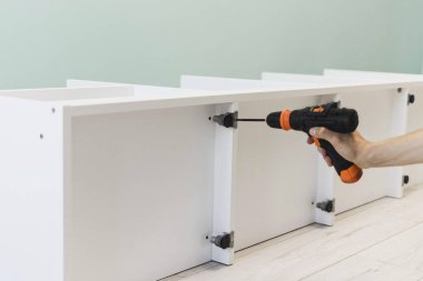 Genç bir zanaatkar mobilya montajı yapıyor. Teyidi yakın plan çekiyoruz. Profesyonel mobilya montajı. Yeni mobilya montajı. Mobilya kurulumu.