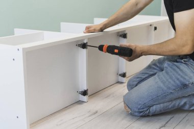 Genç bir zanaatkar mobilya montajı yapıyor. Teyidi yakın plan çekiyoruz. Profesyonel mobilya montajı. Yeni mobilya montajı. Mobilya kurulumu.