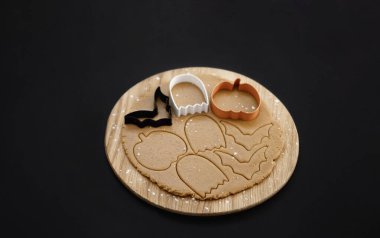 Karanlık bir arka planda Cadılar Bayramı zencefilli kurabiyeleri. Cadılar Bayramı partisi için ev yapımı kurabiyeler. Balkabağı, hayalet, yarasa, mumya, iskelet. Cadılar Bayramı arkaplanı ve mesaj için boşluk. Üst Manzara. Model.