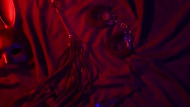 Handcuffs, leather whip flogger, mask and choker for BDSM sex with submission and domination. Concept of erotic adult sex toys