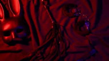 Handcuffs, leather whip flogger, mask and choker for BDSM sex with submission and domination. Concept of erotic adult sex toys