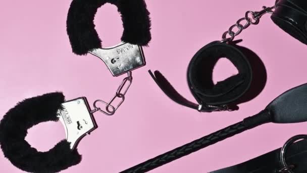 服従と支配とBdsmセックスのための鞭のフロッガー Aセットの大人親密なエロセックスおもちゃオンピンクの背景 — ストック動画