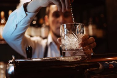 Barmen bir restoranda bardakta buzlu bir kokteyl hazırlar.