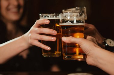 Mutlu dostların ellerinde hafif biralı bardaklar.