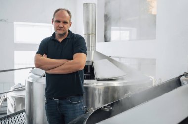 Modern bir bira fabrikasındaki bira üreticisi üretimi kontrol ediyor.