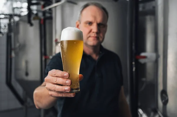 酿酒厂里的酿酒师 用的是一杯新鲜啤酒 — 图库照片
