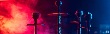 Geleneksel Asyalı rahatlaması için dinlenme odasının iç tarafındaki masada shisha kaseleri ve kömürleri olan hookahlar.