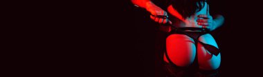 dominant man slaps a leather whip on the sexy ass of a submissive girl in BDSM sex. Panoramic wide horizontal photo for banner head cover