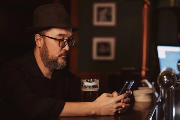 Adam Barda Elinde Birayla Otururken Cep Telefonu Akıllı Telefonu Kullanıyor — Stok fotoğraf