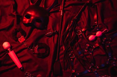 Vibrator, whip, handcuffs and mask for BDSM sex with submission and domination. A set of adult erotic sex toys