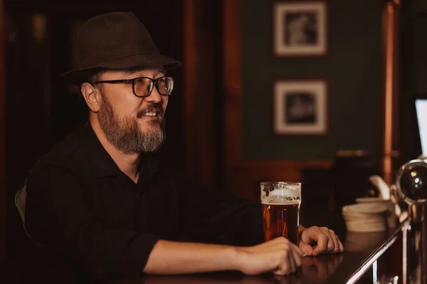 Bir Barın Tezgahında Elinde Bir Bardak Birayla Gülümseyen Adam — Stok fotoğraf