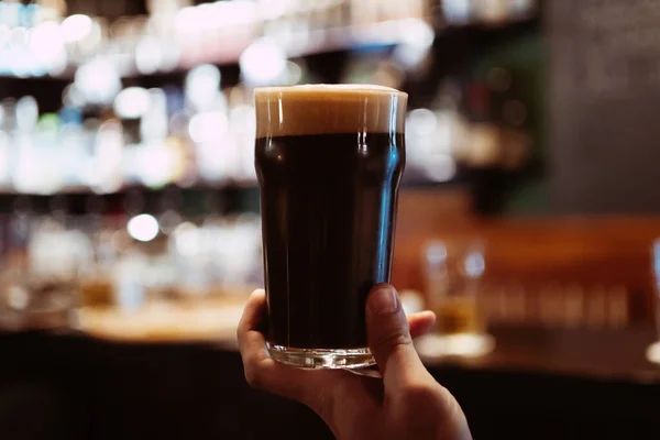 Barın Arkasındaki Barda Elinde Köpüklü Siyah Bira Köpüklü Bir Adam — Stok fotoğraf