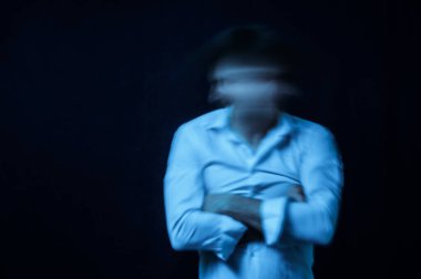 Zihinsel bozuklukları ve akıl hastalıkları olan, siyah arka planda deli gömleği giymiş bir adamın şizofren portresi.