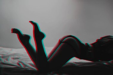 Seksi vücutlu ince bir kadın ve güzel iç çamaşırlı bir kalça yatakta cinsel olarak poz veriyor. 3 boyutlu sanal gerçeklik efektiyle siyah ve beyaz