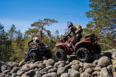 KARELİYA, RUSSIA REÜKLİK - CIRCA HAZİRAN 2022: Karelia 'da Ladoga Kupası 2022 off-road turnuvası. ATV yarışçısı doğadaki bir yarışta kayalara biner.