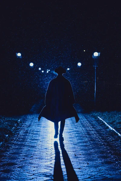 男侦探戴着帽子 晚上穿着雨衣 在雨中的城市里 穿着黑色胶卷的风格 — 图库照片