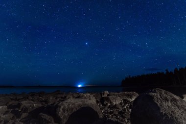 Yıldızlı gökyüzü takımyıldızları, galaksileri, samanyolu ve nehirdeki birçok yıldızın üzerinde taşları ve ormanı var. Manzaranın Astrofotoğrafçılığı