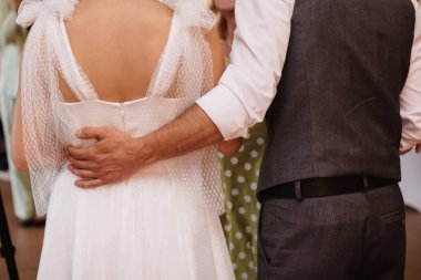 Damat, düğün gününde gelini kucaklıyor. Şenlik sırasında.