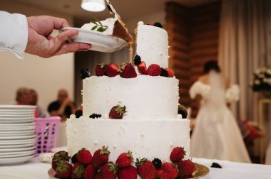Damat, düğün pastasını bıçakla keser.