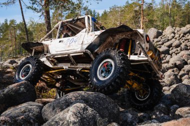 KARELİYA, RUSSIA REUKLİK - CIRCA HAZİRAN, 2022: Ladoga Gölü çevresindeki off-road turnuvası Ladoga Kupası 2022. 4x4 Mercedes cipi yarışta kayalıklarda geziyor.