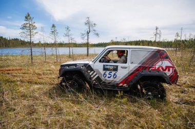 KARELİYA, RUSSIA REUKLİK - CIRCA HAZİRAN, 2022: Ladoga Gölü çevresindeki off-road turnuvası Ladoga Kupası 2022. Niva 4x4 off-road arabaları doğadaki bir bataklıkta yarışır.