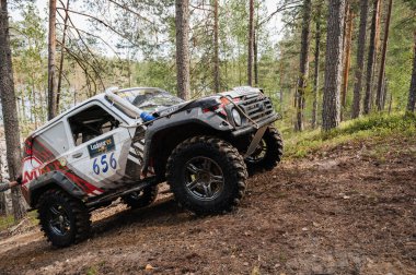 KARELİYA, RUSSIA REUKLİK - CIRCA HAZİRAN, 2022: Ladoga Gölü çevresindeki off-road turnuvası Ladoga Kupası 2022. 4x4 SUV cipi orman boyunca bir yarışta tepeye tırmanır.