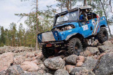 KARELİYA, RUSSIA REUKLİK - CIRCA HAZİRAN, 2022: Ladoga Gölü çevresindeki off-road turnuvası Ladoga Kupası 2022. Off-road Jeep UAZ 4x4 doğadaki kayaların üzerinde yarışır.