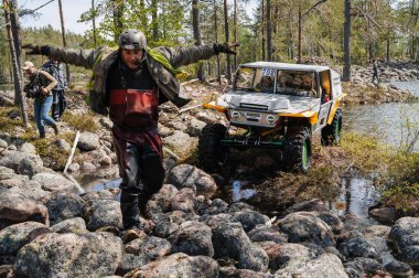 KARELİYA, RUSSIA REUKLİK - CIRCA HAZİRAN, 2022: Ladoga Gölü çevresindeki off-road turnuvası Ladoga Kupası 2022. 4x4 SUV yazın doğada bir off-road yarışında gölde suyun üzerinde gider.