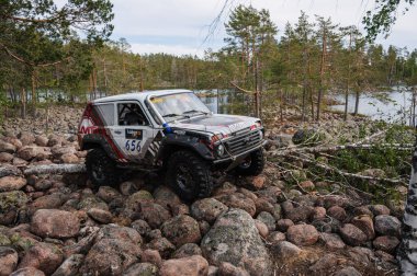 KARELİYA, RUSSIA REUKLİK - CIRCA HAZİRAN, 2022: Ladoga Gölü çevresindeki off-road turnuvası Ladoga Kupası 2022. Off-road Jeep Niva 4x4 Karelia 'daki göl kenarındaki kayalıklarda yarışır.