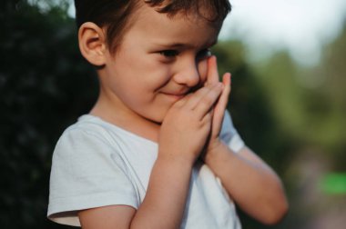 Yazın parkta yürüyen bir anaokulu çocuğunun portresi.