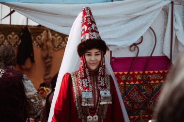 SHYMKENT, KAZAKHSTAN - MARCH 22, 2023: Kazakh girl in a traditional festive Kazakh costume at the celebration of Nauryz clipart