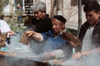 SHYMKENT, KAZAKHSTAN - 22 Mart 2023: Nauryz kutlamaları için barbekü pişiren bir Kazak.