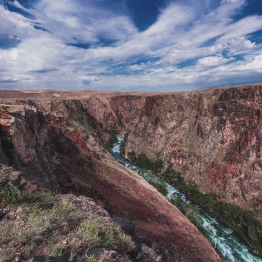 Yazın bulutlu bir gökyüzünün altında Kazakistan 'da Kara Charyn Kanyonu manzarası
