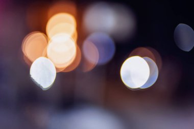 Bulanık arkaplan ve çok renkli bokeh ile gece kentinde sokakta
