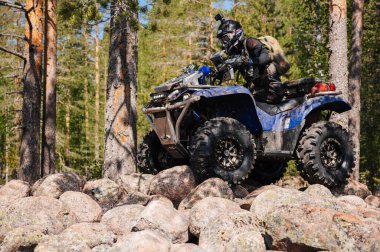 KARELİYA, RUSSIA REÜKLİK - CIRCA HAZİRAN 2022: Karelia 'da Ladoga Kupası 2022 off-road turnuvası. ATV yarışçısı doğadaki bir yarışta kayalara biner.