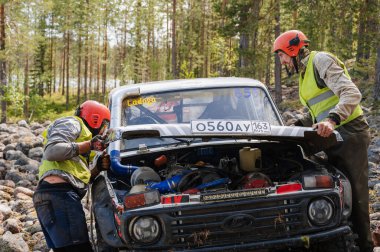 KARELİYA, RUSSIA REUKLİK - CIRCA HAZİRAN, 2022: Ladoga Gölü çevresindeki off-road turnuvası Ladoga Kupası 2022. Yarışçılar yarış pistinde SUV Niva 'yı tamir ediyorlar.