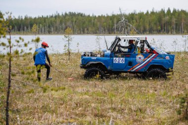 KARELİYA, RUSSIA REUKLİK - CIRCA HAZİRAN, 2022: Ladoga Gölü çevresindeki off-road turnuvası Ladoga Kupası 2022. Off-road Jeep UAZ 4x4 doğadaki bir bataklıkta yarışır.