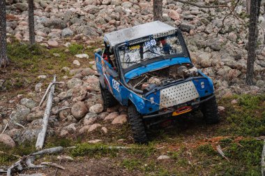 KARELİYA, RUSSIA REUKLİK - CIRCA HAZİRAN, 2022: Ladoga Gölü çevresindeki off-road turnuvası Ladoga Kupası 2022. Off-road Jeep UAZ 4x4 doğadaki kayaların üzerinde yarışır.