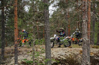 KARELİYA, RUSSIA REÜKLİK - CIRCA HAZİRAN 2022: Karelia 'da Ladoga Kupası 2022 off-road turnuvası. Spora dayanıklı motosikletli motosikletçiler zorlu bir orman arazisinde motosiklet yarışı yapıyorlar.