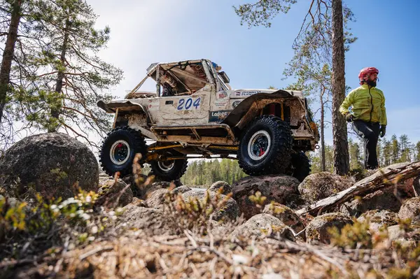 KARELİYA, RUSSIA REUKLİK - CIRCA HAZİRAN, 2022: Ladoga Gölü çevresindeki off-road turnuvası Ladoga Kupası 2022. 4x4 Mercedes cipi yarışta kayalıklarda geziyor.