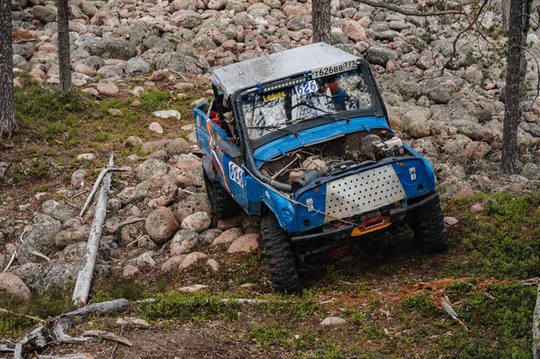 KARELİYA, RUSSIA REUKLİK - CIRCA HAZİRAN, 2022: Ladoga Gölü çevresindeki off-road turnuvası Ladoga Kupası 2022. Off-road Jeep UAZ 4x4 doğadaki kayaların üzerinde yarışır.