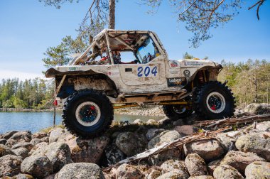 KARELİYA, RUSSIA REUKLİK - CIRCA HAZİRAN, 2022: Ladoga Gölü çevresindeki off-road turnuvası Ladoga Kupası 2022. 4x4 Mercedes cipi yarışta kayalıklarda geziyor.