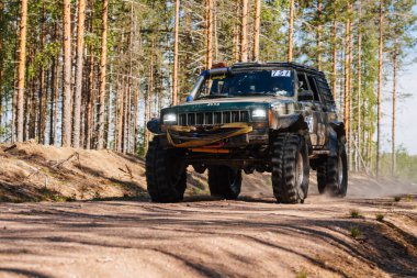 KARELİYA, RUSSIA REUKLİK - CIRCA HAZİRAN, 2022: Ladoga Gölü çevresindeki off-road turnuvası Ladoga Kupası 2022. 4x4 off-road cipi tozlu bir orman yolunda hızla gidiyor.