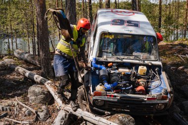 KARELİYA, RUSSIA REUKLİK - CIRCA HAZİRAN, 2022: Ladoga Gölü çevresindeki off-road turnuvası Ladoga Kupası 2022. Niva 4x4 off-road arabaları ormanın ortasında kayalıklarda yarışır.