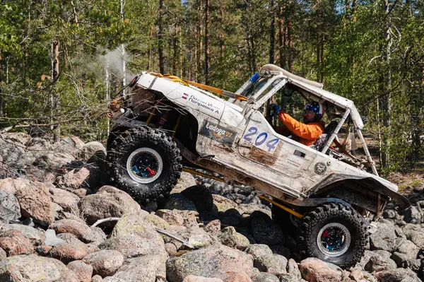 KARELİYA, RUSSIA REUKLİK - CIRCA HAZİRAN, 2022: Ladoga Gölü çevresindeki off-road turnuvası Ladoga Kupası 2022. 4x4 Mercedes cipi yarışta kayalıklarda geziyor.