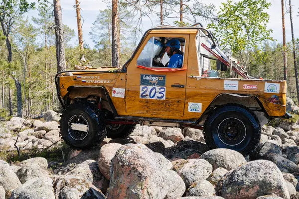 KARELİYA, RUSSIA REUKLİK - CIRCA HAZİRAN, 2022: Ladoga Gölü çevresindeki off-road turnuvası Ladoga Kupası 2022. 4x4 Mercedes off-road yarışında kayaların üzerinden geçiyor.