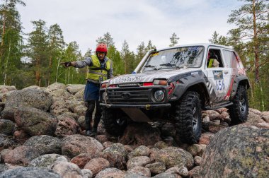 KARELIA, RUSSIA - CIRCA JUNE, 2022: Ladoga Gölü çevresindeki Off-road turnuvası Ladoga Kupası 2022. Off-road cipi Niva 4x4 araba doğada kayalıklarda yarışır.