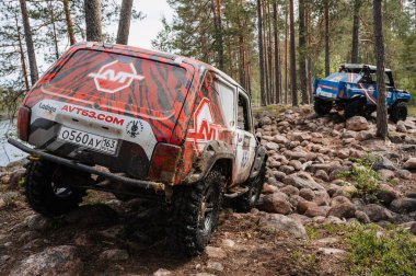 KARELIA, RUSSIA - CIRCA JUNE, 2022: Ladoga Gölü çevresindeki Off-road turnuvası Ladoga Kupası 2022. Off-road cipi Niva 4x4 araba doğada kayalıklarda yarışır.