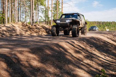 KARELIA, RUSSIA - CIRCA JUNE, 2022: Ladoga Gölü çevresindeki Off-road turnuvası Ladoga Kupası 2022. 4x4 off-road cipi tozlu bir orman yolunda hızla gidiyor.